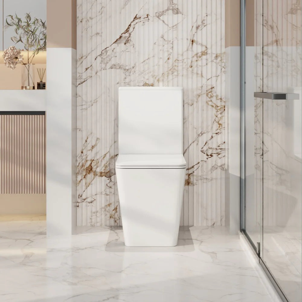 White toilet in a modern bathroom with marble walls and floor.