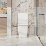 White toilet in a modern bathroom with marble walls and floor.