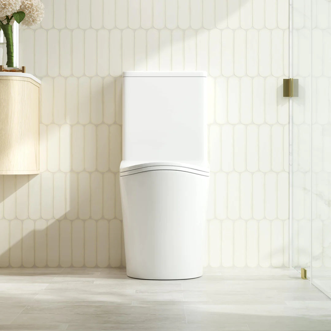 Modern white toilet in a bathroom with light wood flooring and tiled walls.