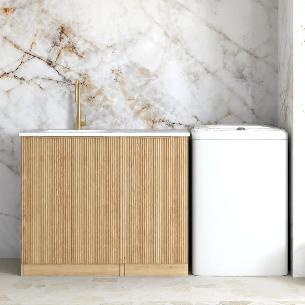 Bathroom with marble wall, wooden cabinet, and white trash bin.