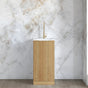 Modern bathroom sink with gold finish against a marble wall