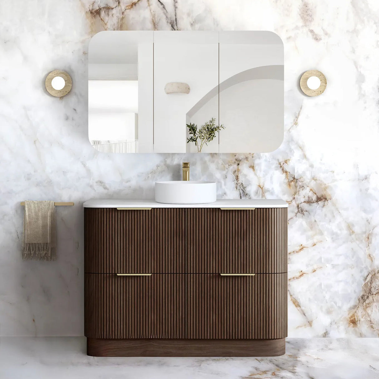 A modern bathroom vanity set featuring a dark brown ribbed cabinet with gold handles, a white countertop, a white vessel sink, a matching wall mirror, and a white marble-look wall and floor in a luxury bathroom setting.
