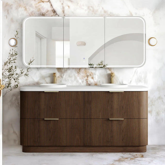 A modern double-sink bathroom vanity with a ribbed brown wood cabinet, white countertop, and a large triptych mirror mounted on a white marble wall.
