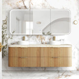 Bathroom vanity with wooden cabinet, marble countertop, and large mirror against a marble wall.
