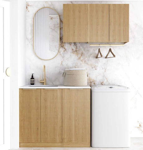 Bathroom with wooden cabinets, white sink, and marble wall.