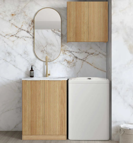 Modern bathroom with wooden vanity, mirror, and white storage unit against a marble wall.