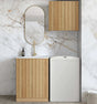 Modern bathroom with wooden vanity, mirror, and white storage unit against a marble wall.