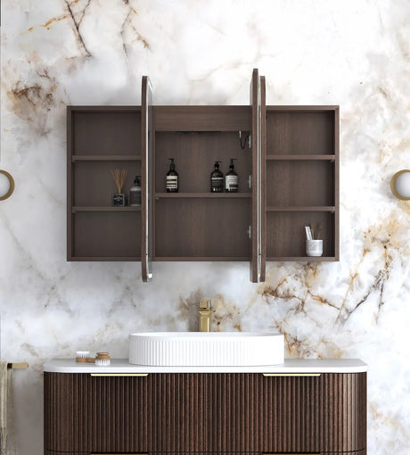 Bathroom vanity with open cabinet against a marble wall