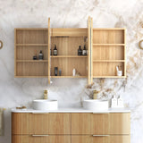 A wall-mounted wooden bathroom mirror cabinet with open doors, styled above a double-sink vanity in a bright bathroom with a marble wall and gold fixtures.