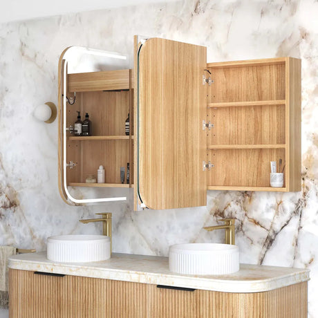 Bathroom vanity with wooden cabinets, marble wall, and white countertop.