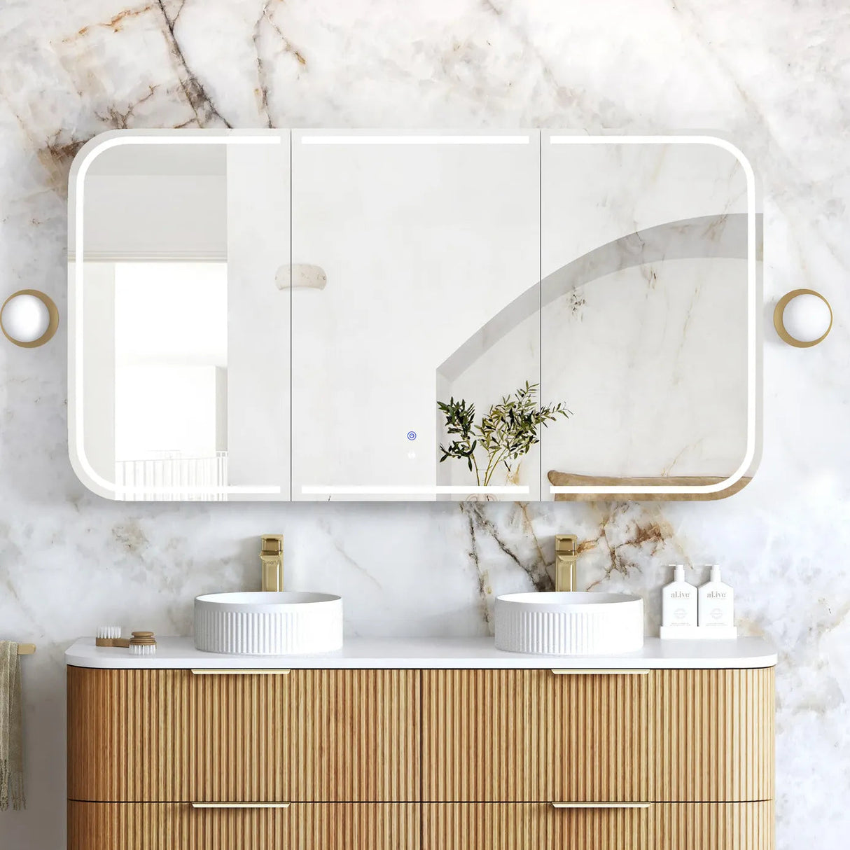 Bathroom vanity with wooden cabinets, white countertop, and large mirror on marble wall.