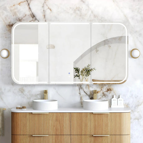 Bathroom vanity with wooden cabinets, white countertop, and large mirror on marble wall.