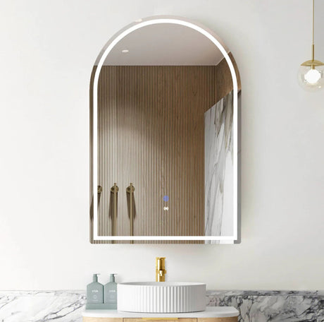 Bathroom with a large arch-shaped mirror, sink, and toiletries.