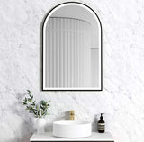 Bathroom with a decorative mirror, sink, and toiletries against a textured white wall.