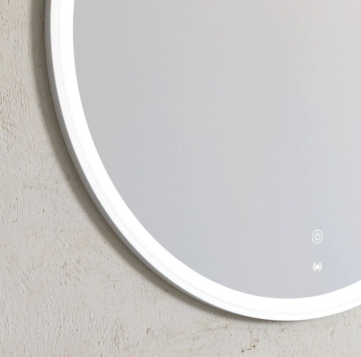 Round mirror with a silver frame on a light gray wall