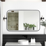 Bathroom with a large mirror, sink, and decorative elements.