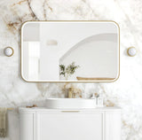 Bathroom vanity with a rectangular mirror on a marble wall