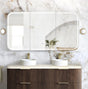 Bathroom vanity with double sink, mirror, and marble wall.