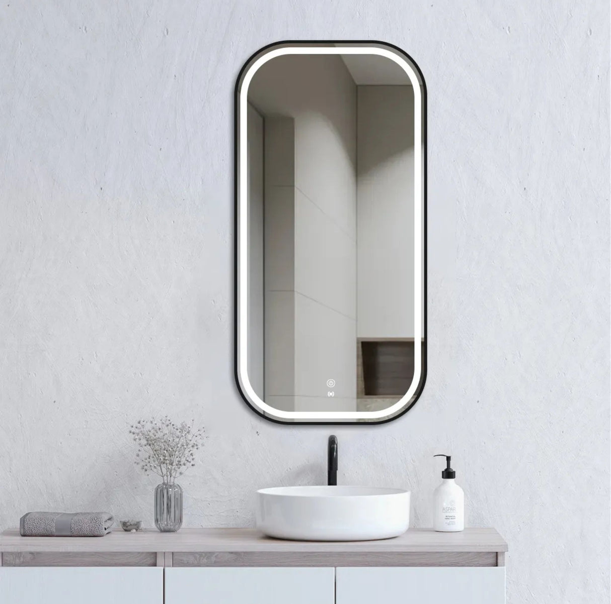 Bathroom vanity with a mirror, sink, and decorative items on a light gray wall.