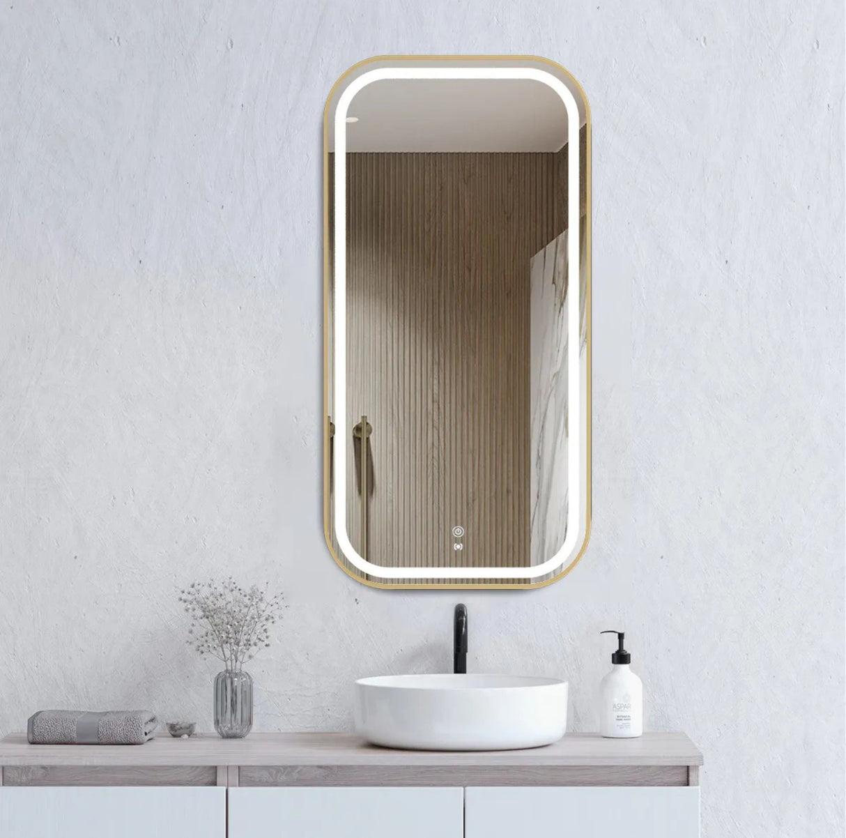 Bathroom vanity with a rectangular mirror, sink, and decorative items on a light gray wall.