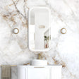 Bathroom vanity with mirror and sink against a marble wall