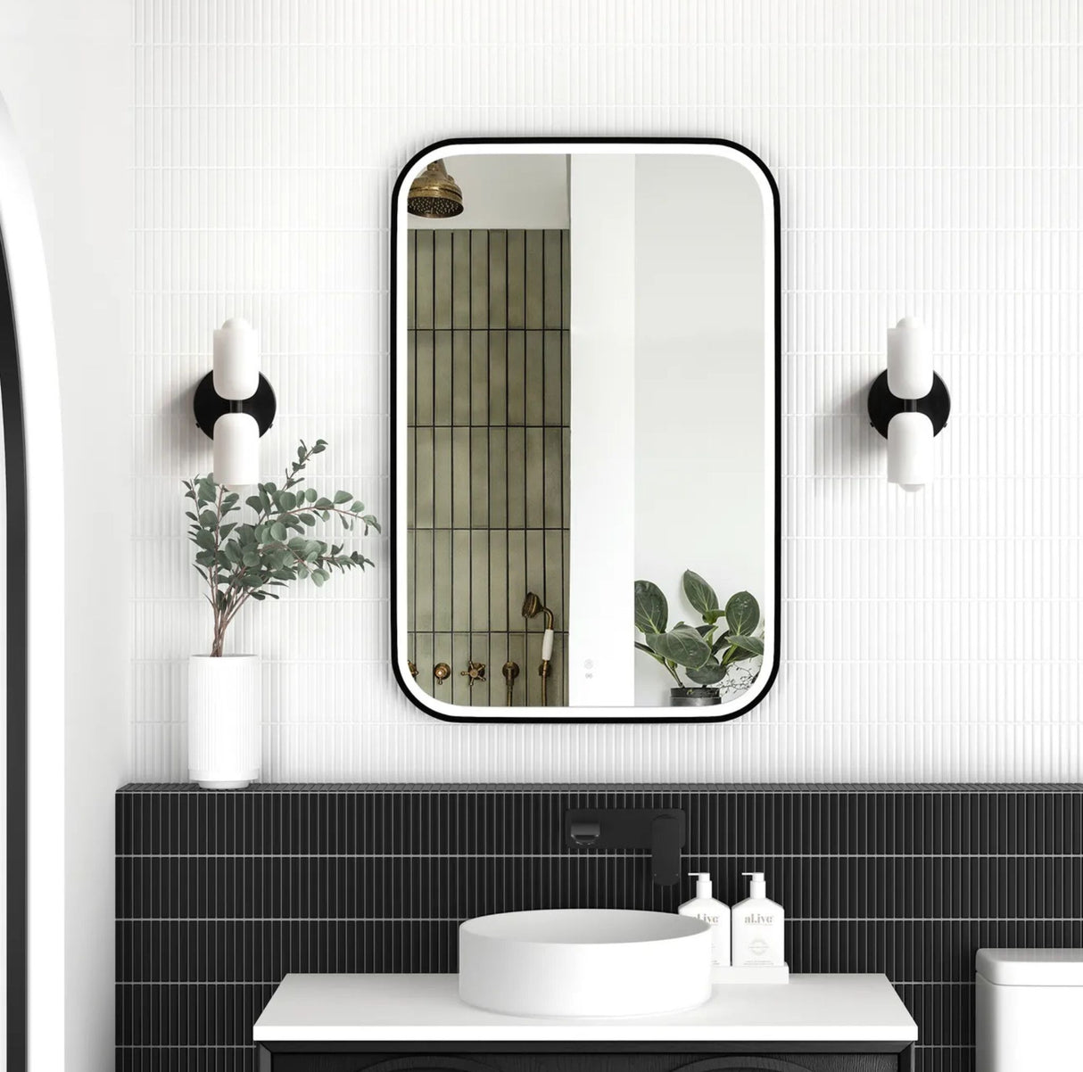 Bathroom with a large rectangular mirror, black wall sconces, and a sink.