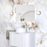 Bathroom vanity with white sink and mirror against a marble wall.
