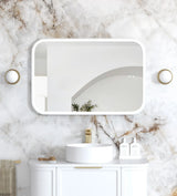 Bathroom with marble wall, white sink, and gold fixtures