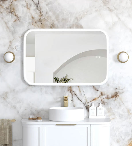 Bathroom with marble wall, white sink, and gold fixtures