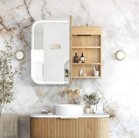 Bathroom with wooden vanity, mirror, and shelves against a marble wall.