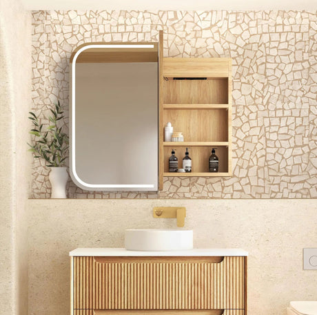 Bathroom vanity with wooden cabinet, mirror, and sink against a mosaic tile wall.
