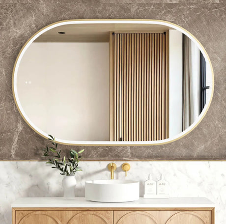 Bathroom vanity with oval mirror, sink, and decorative elements.