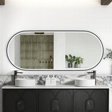 Bathroom vanity with black cabinets, white countertop, and large oval mirror.