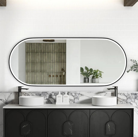 Bathroom vanity with black cabinets, white countertop, and large oval mirror.