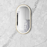oval mirror with gold frame on a marble wall