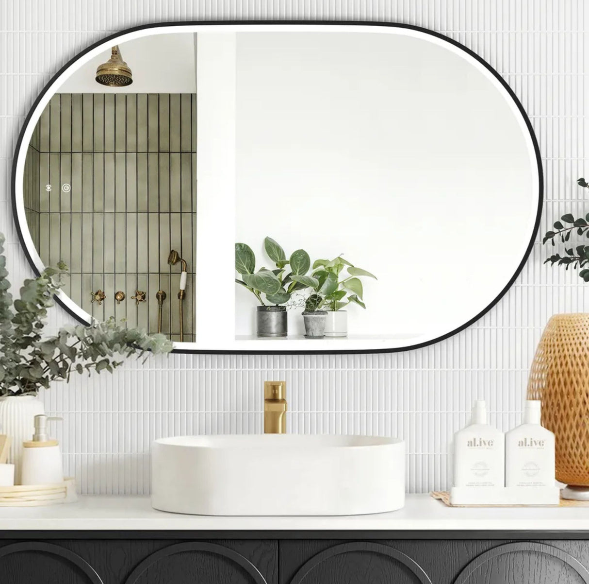 Bathroom with a large oval mirror, white sink, and decorative elements.
