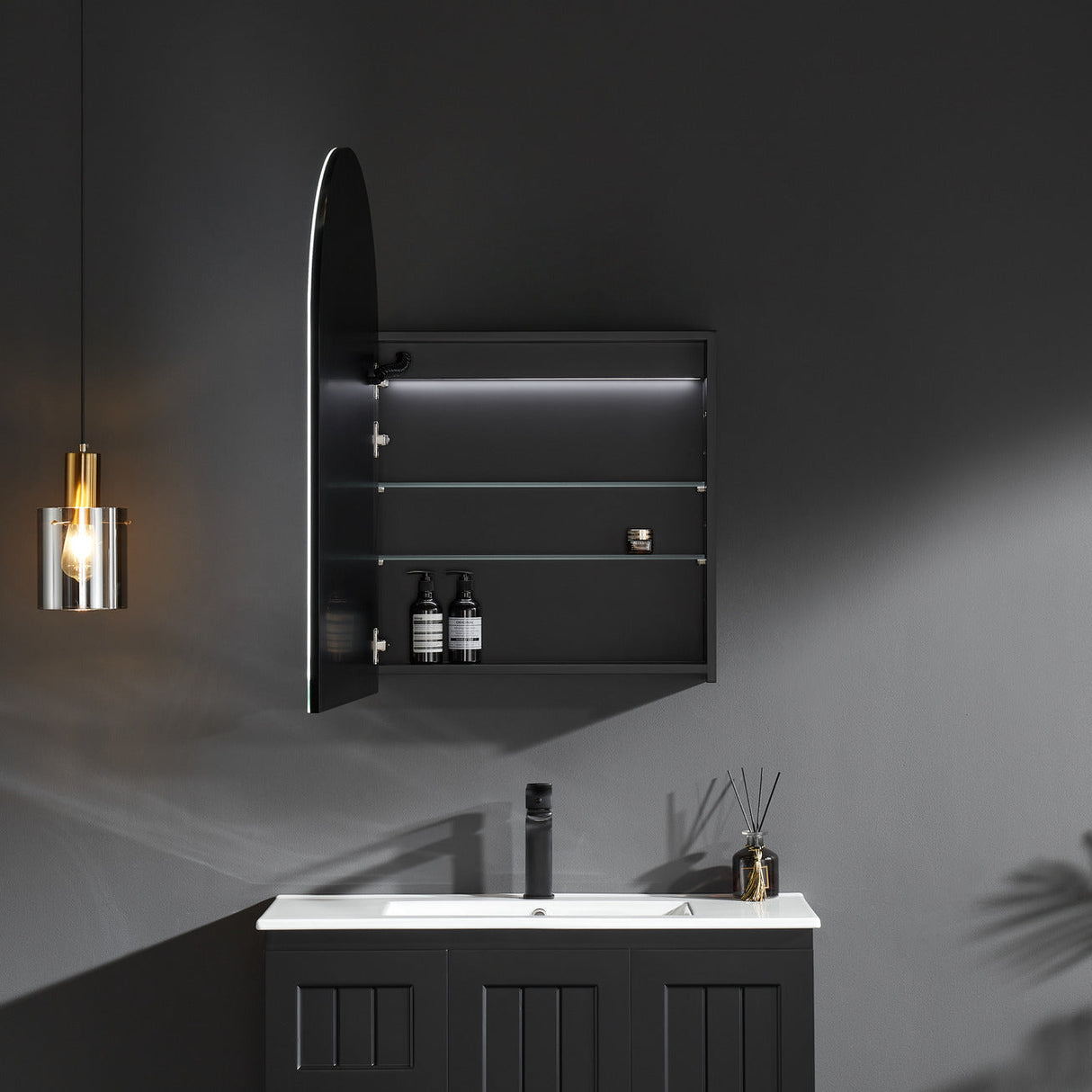Bathroom setup with a black cabinet, sink, and decorative elements on a dark wall.