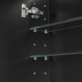 Close-up of a glass shelf with metal brackets on a black background