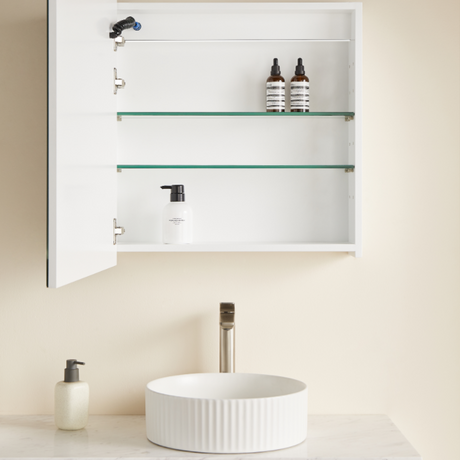 Bathroom setup with a white sink, glass shelves, and toiletries.