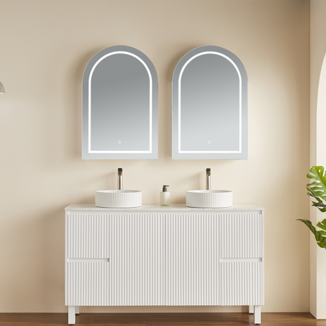 Bathroom vanity with two sinks and mirrors on a beige wall.