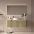 Modern bathroom vanity with illuminated mirror, sink, and decorative elements.