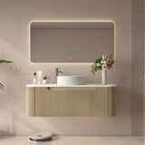 Modern bathroom vanity with illuminated mirror, sink, and decorative elements.