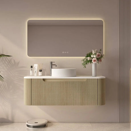 Modern bathroom vanity with illuminated mirror, sink, and decorative elements.