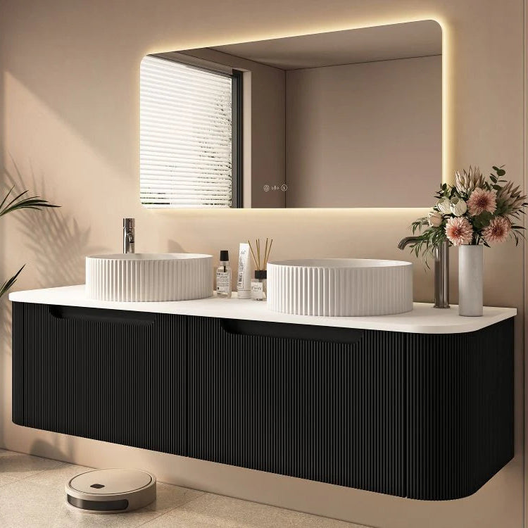 Modern bathroom with a black vanity, white sinks, and a large mirror.