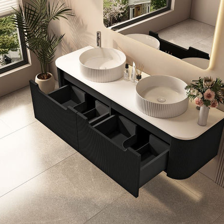 Bathroom vanity with two white sinks and black drawers, featuring a large window and plant.