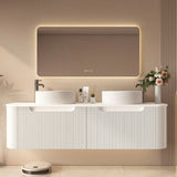 Modern bathroom with a white vanity, illuminated mirror, and decorative elements.