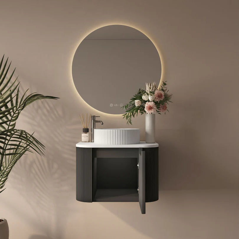 Bathroom vanity with round mirror, sink, and decorative elements on a neutral wall.