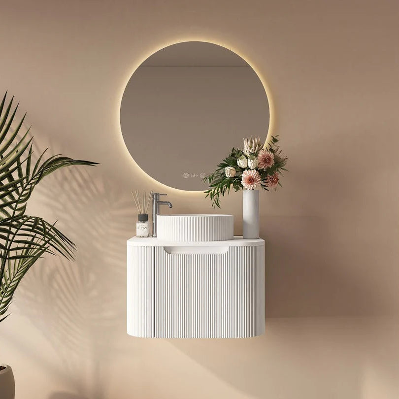 Bathroom setup with a round mirror, sink, and decorative elements on a beige wall.