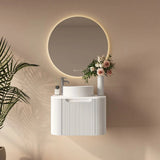 Bathroom setup with a round mirror, sink, and decorative elements on a beige wall.