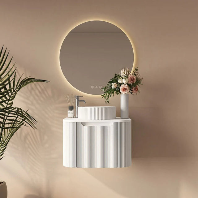 Bathroom setup with a round mirror, sink, and decorative elements on a beige wall.